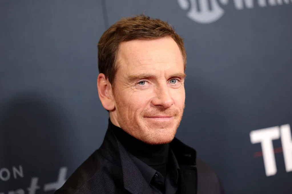 michael fassbender posing for a camera on a red carpet