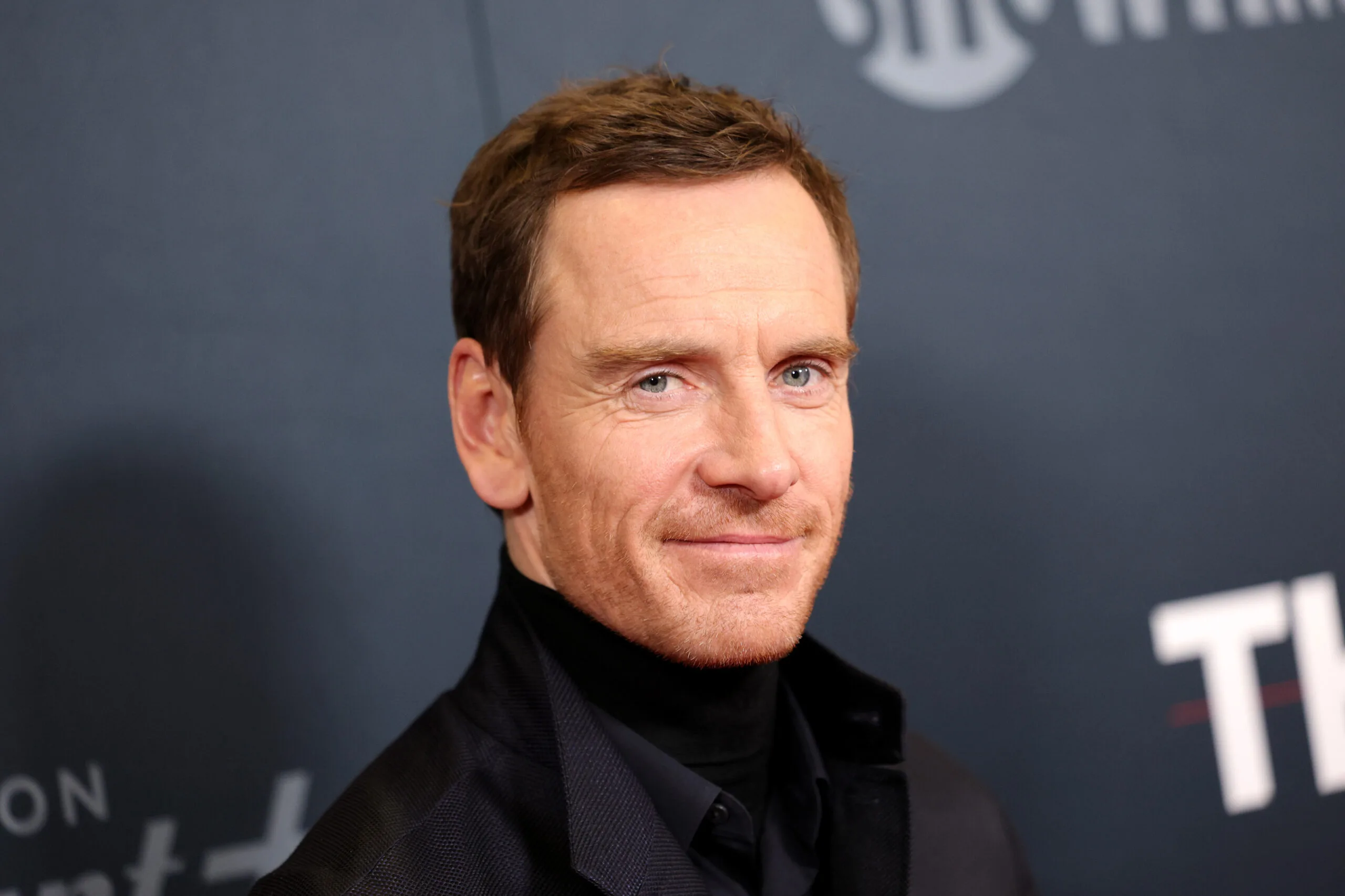 michael fassbender posing for a camera on a red carpet