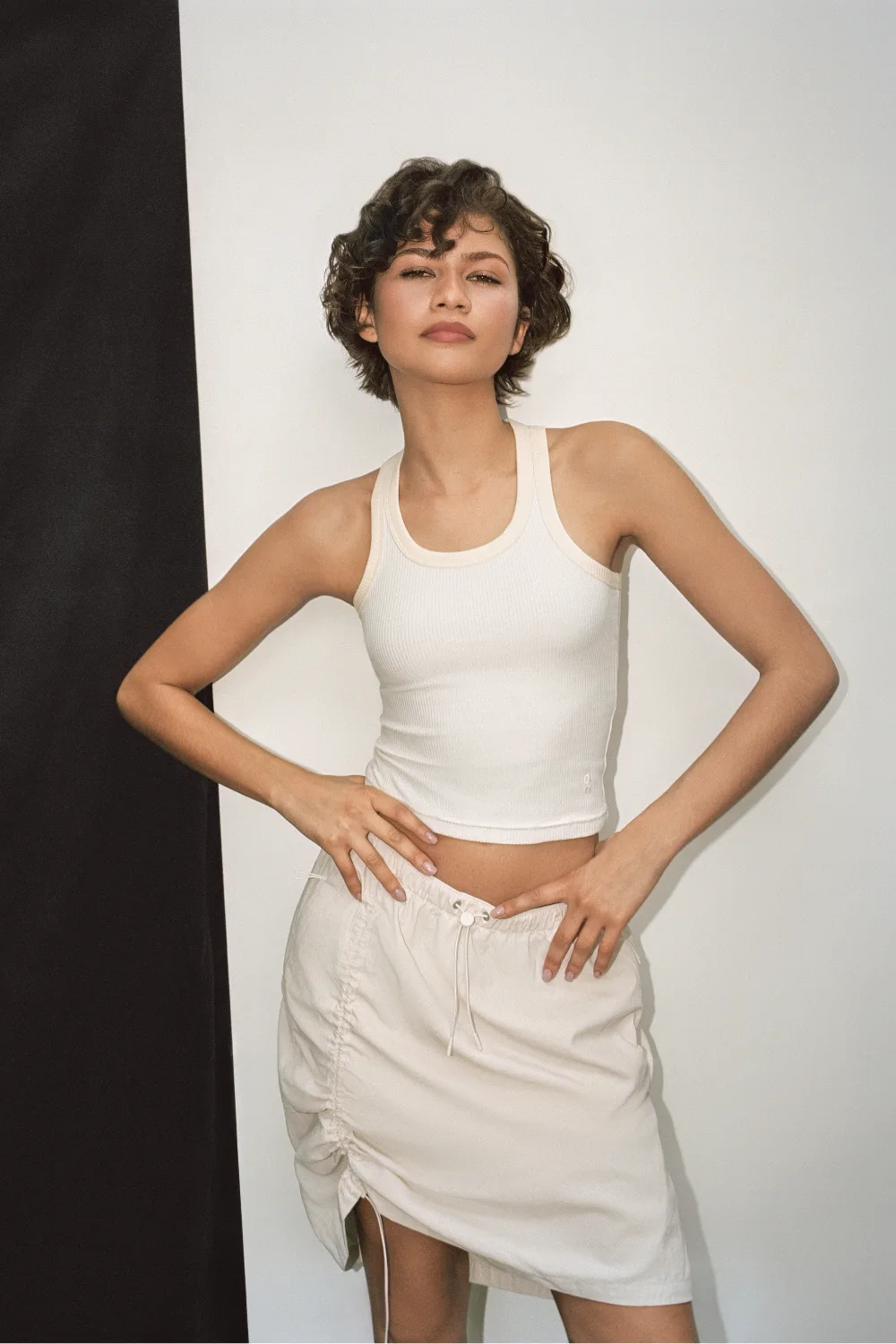 Zendaya On: Zendaya wearing a white tank top and off-white skirt for her latest campaign with On. 