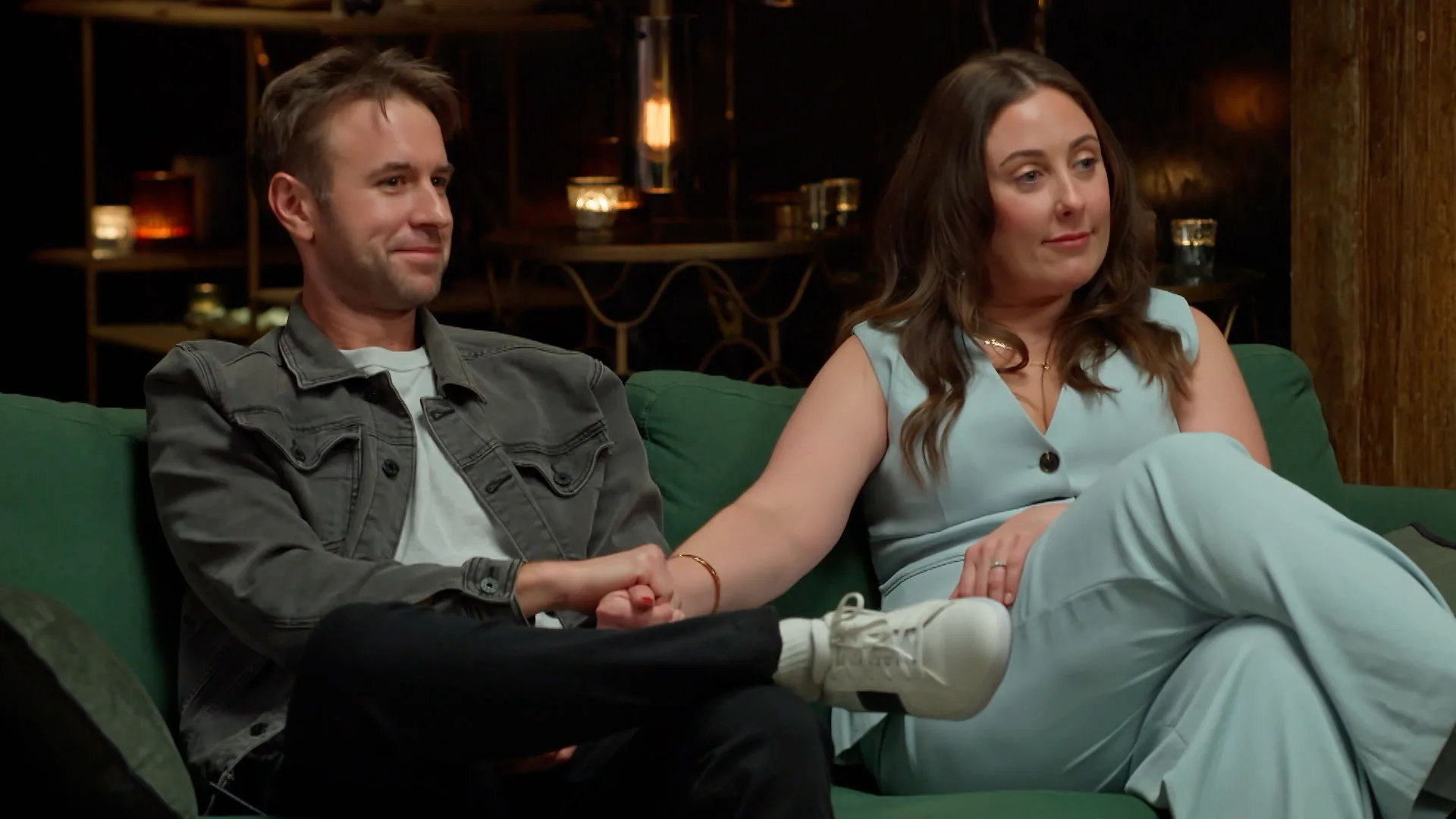 steven and racvhel sitting on the couch holding hands