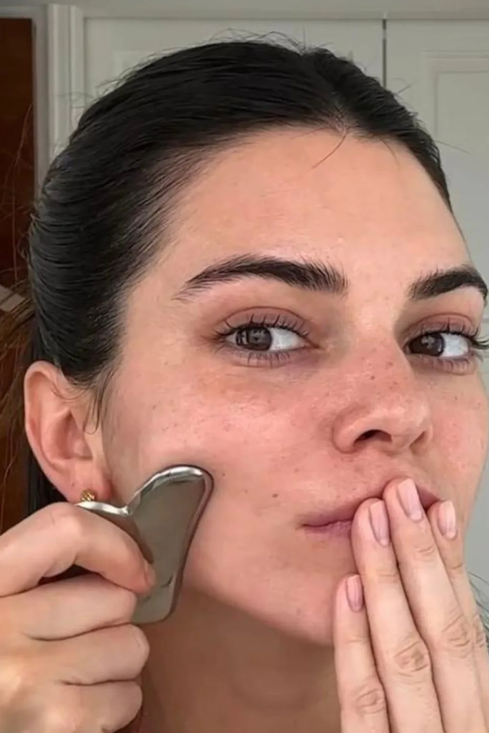 Kendall Jenner using a Gua Sha for a puffy face