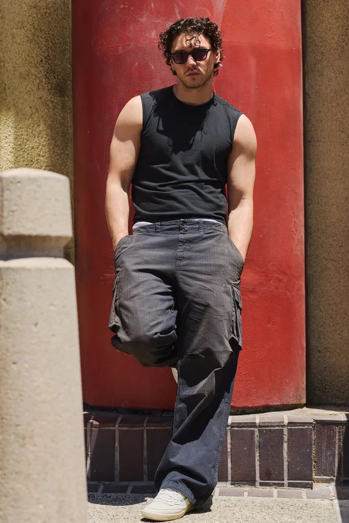 Belmont Cameli wearing a black tank top, black pants and a pair of white reeboks.