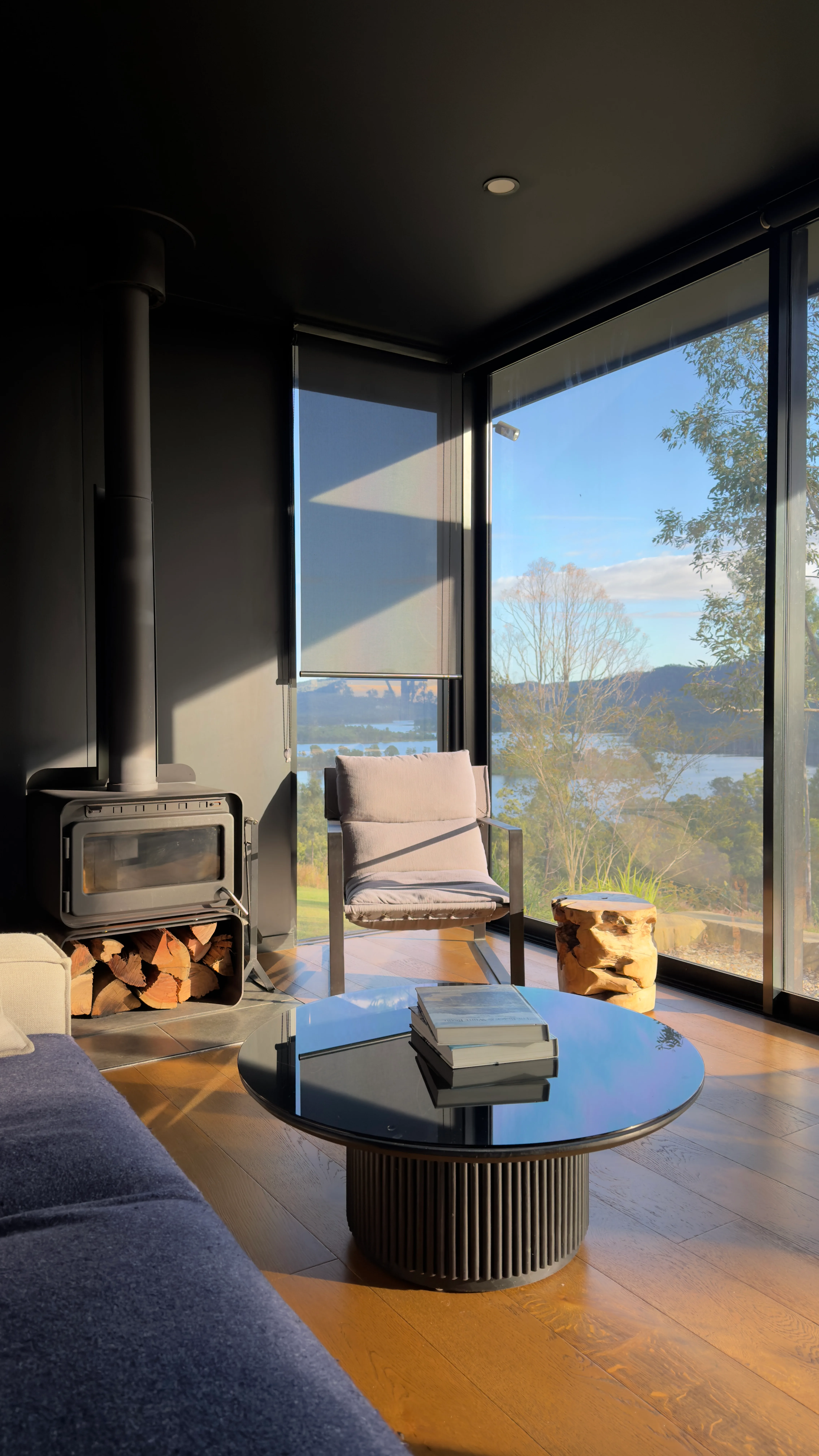 a living room with fireplace overlooking bushland view