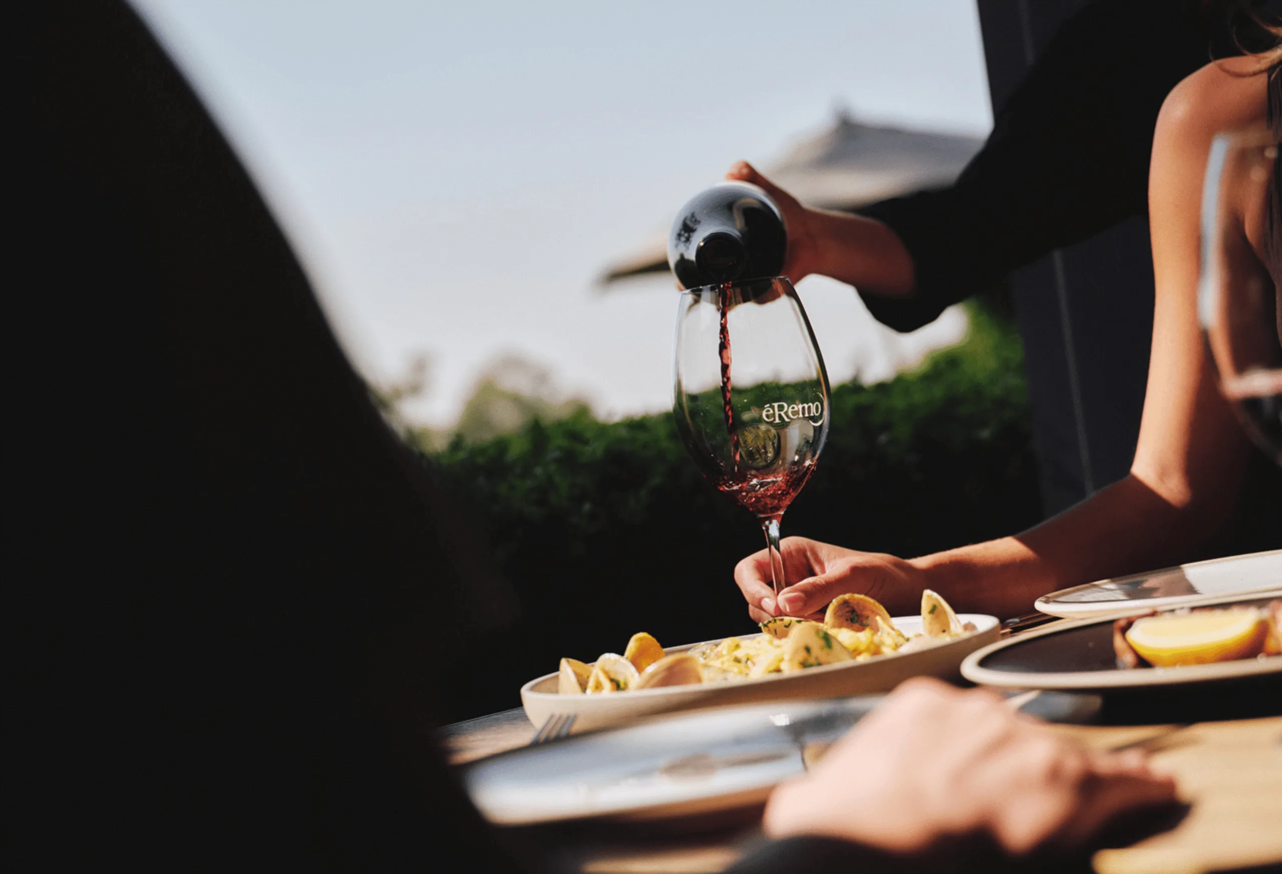 A hand pours a glass of wine. 