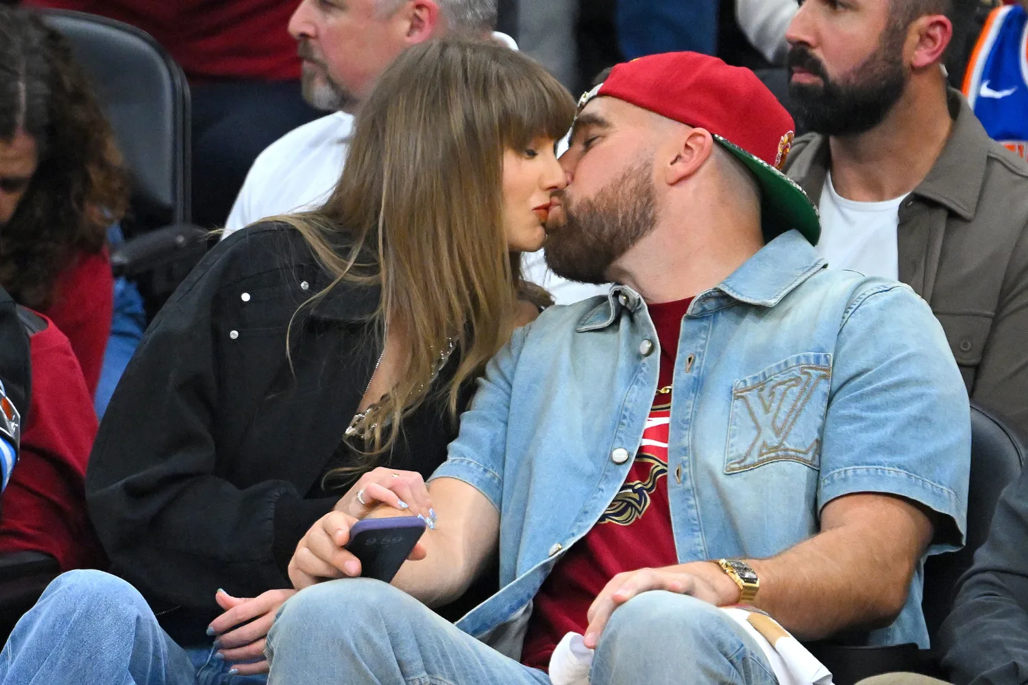 Singer Taylor Swift and Travis Kelce of the Kansas City Chiefs kiss during Game Three between the New York Knicks and the Cleveland Cavaliers in the NBA Eastern Conference Finals at Rocket Arena