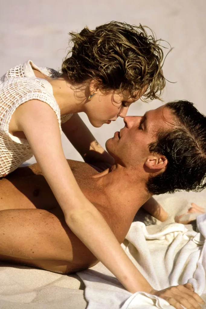 Two models embracing on a beach.