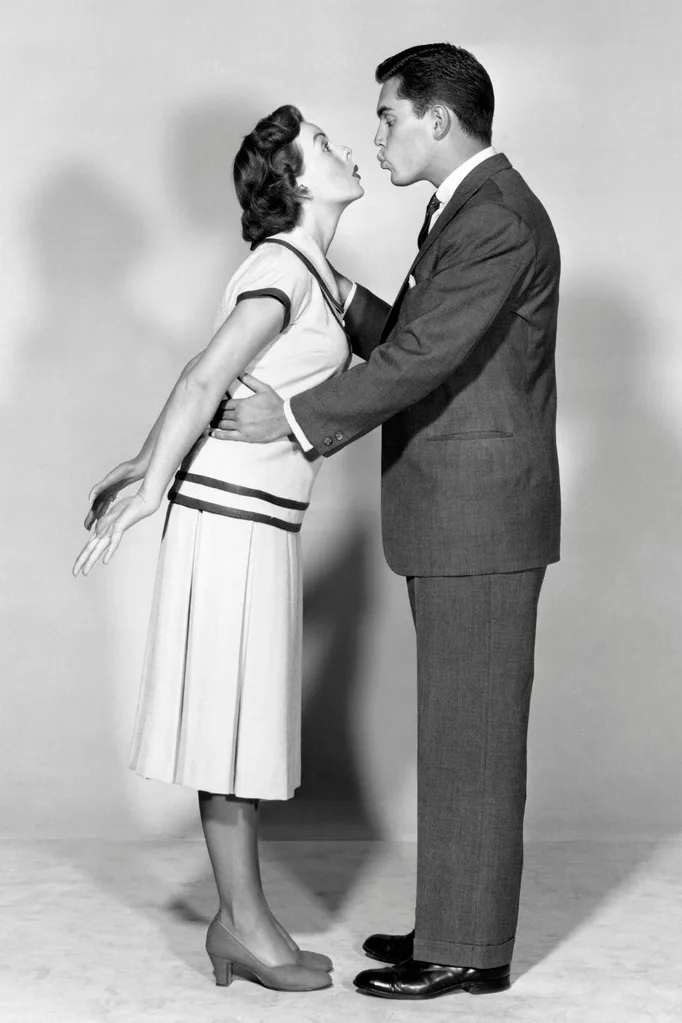 A woman about to kiss a man.
