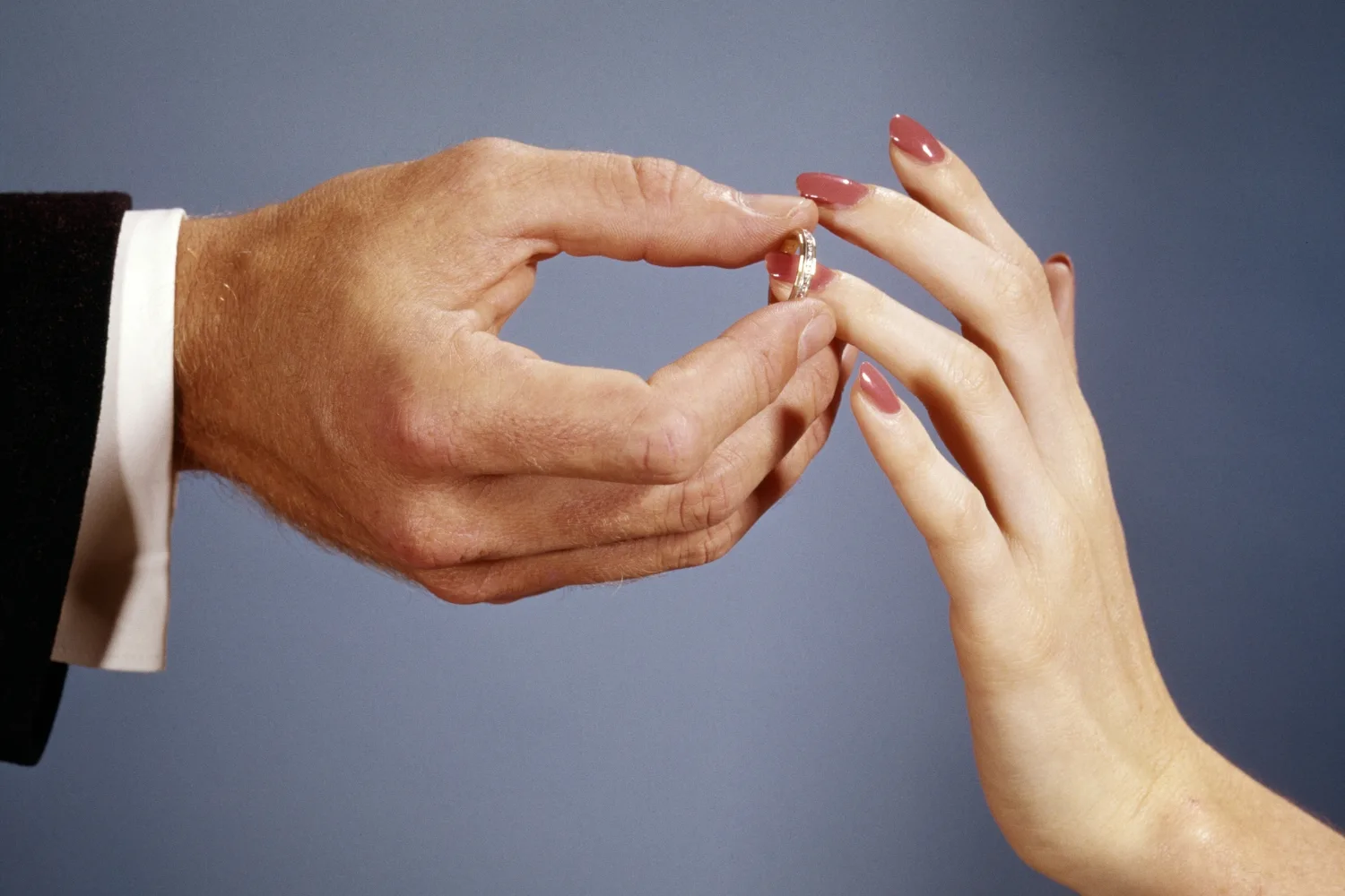 1960s Groom Placing Ring On Bride's Finger.