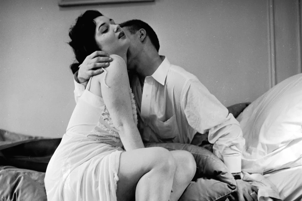 An adulterous couple engaged in a passionate embrace.