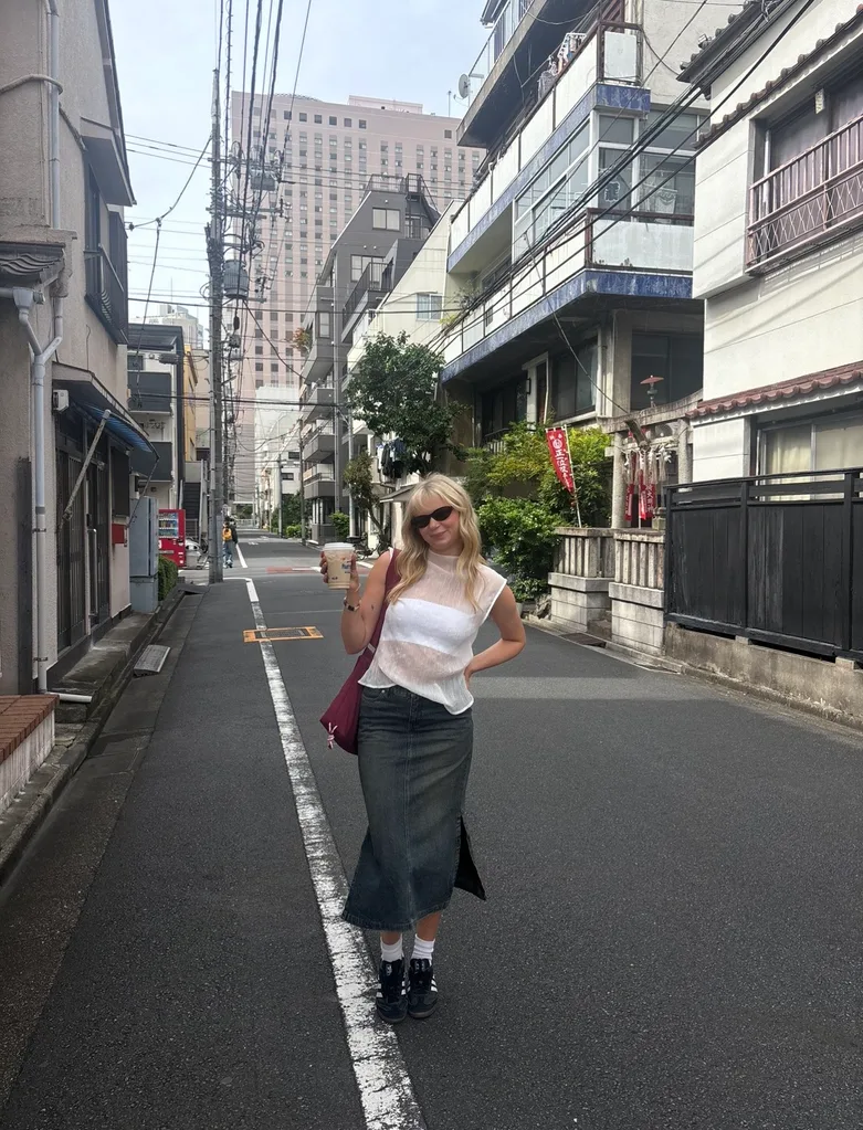 girl in tokyo wearing white sheer high neck blouse and denim midi skirt