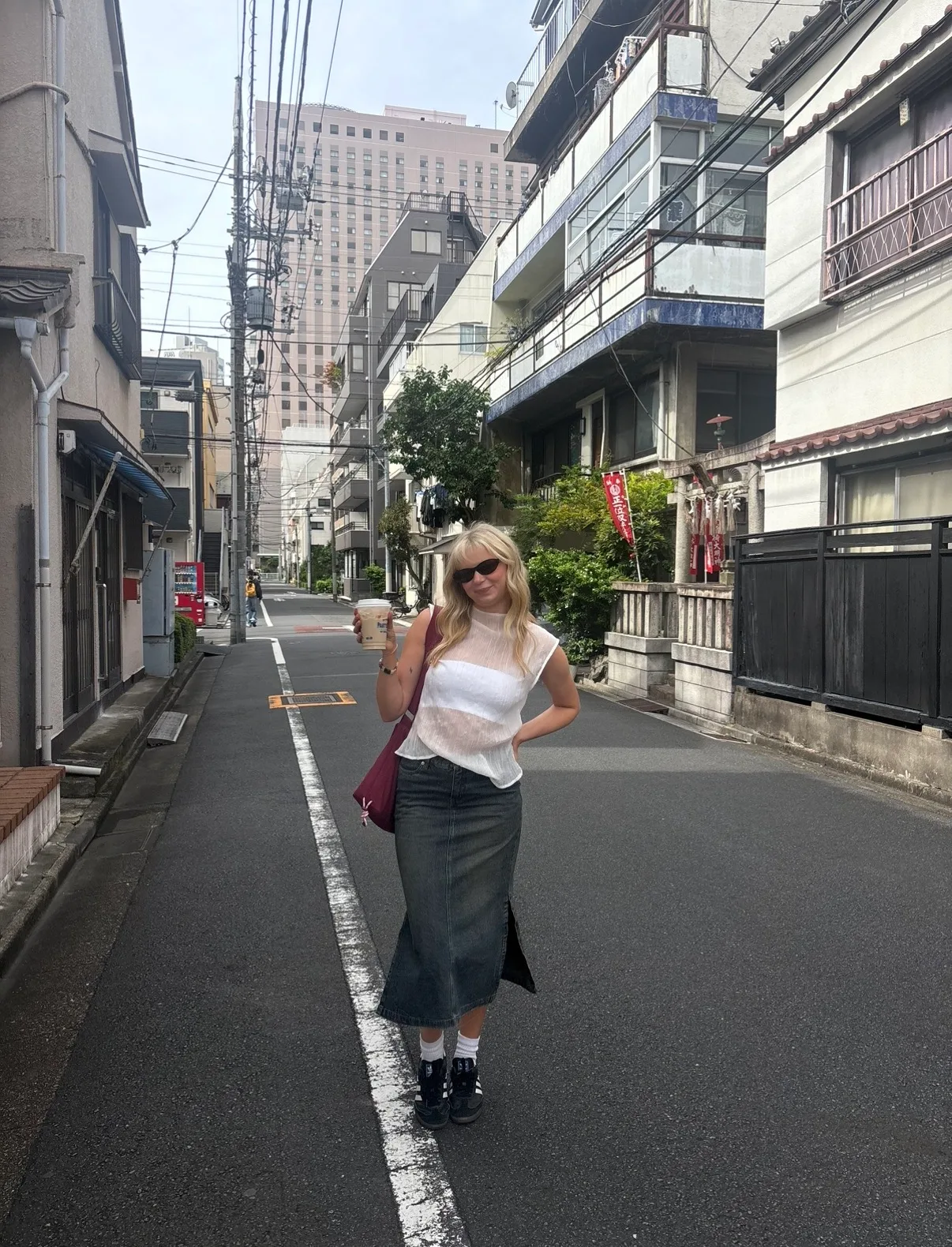 girl in tokyo wearing white sheer high neck blouse and denim midi skirt
