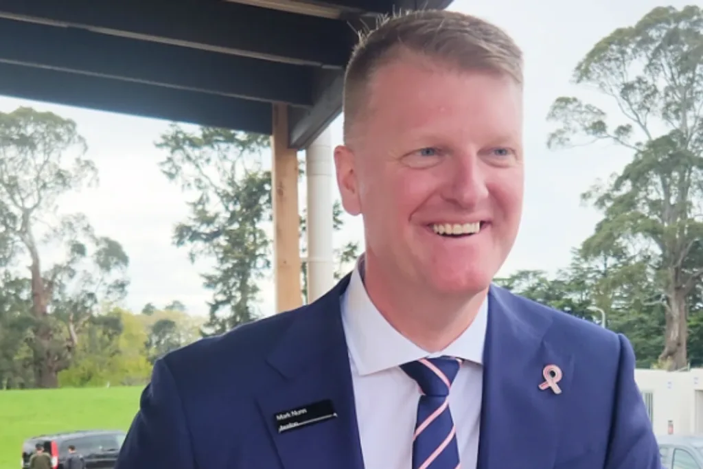 Mark Nunn wearing a navy suit smiling at camera.