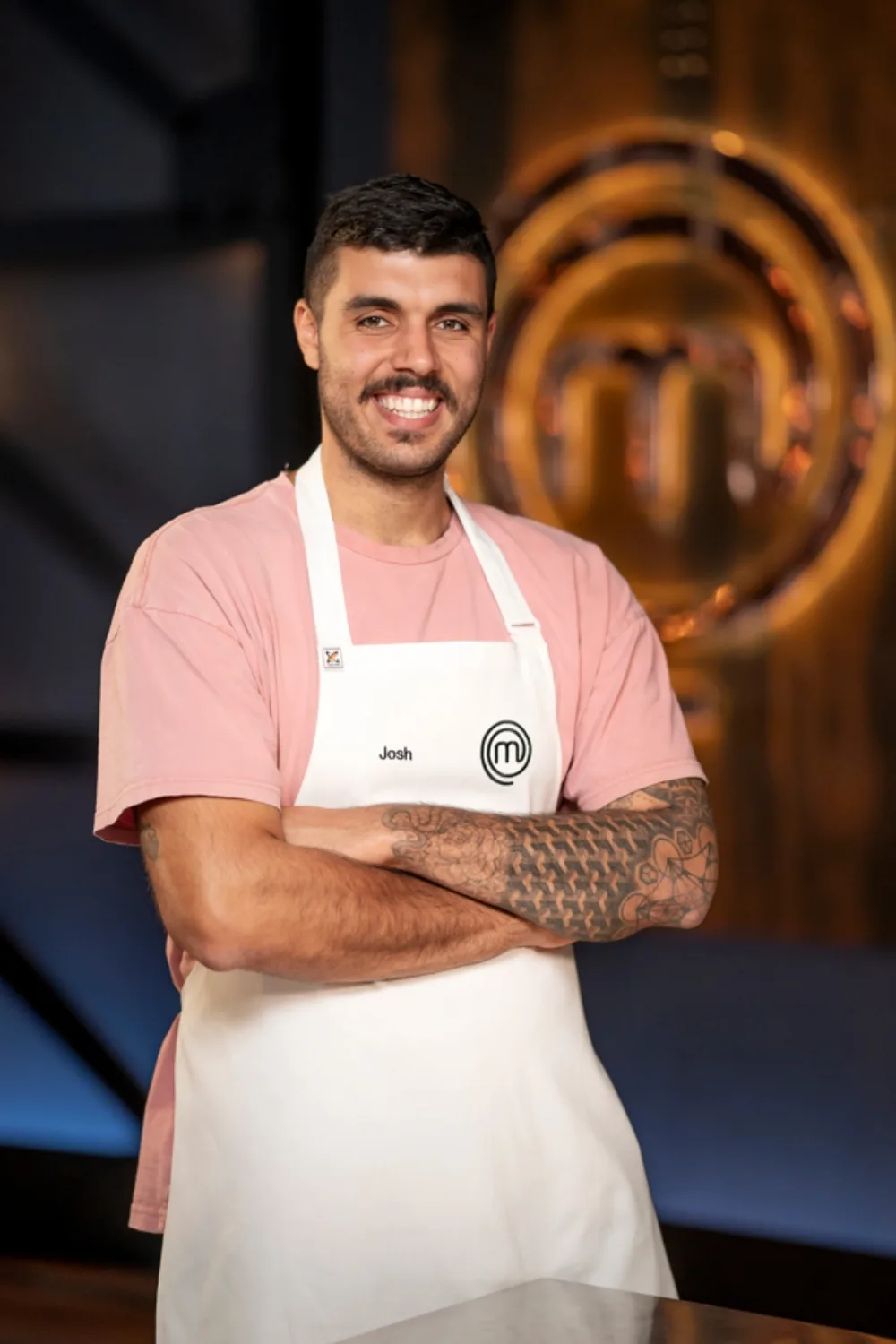 MasterChef contestant Josh Clarke wears white MasterChef apron. 