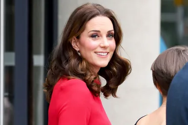 Kate Middleton steps out in a red dress that shows off her growing baby bump