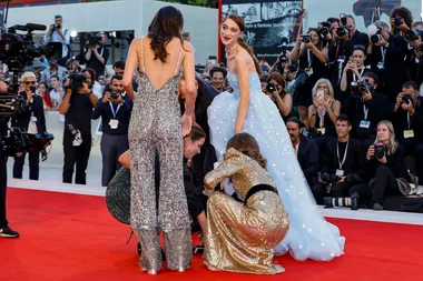 Natalie Portman helps co-star Raffey Cassidy with wardrobe malfunction on the red carpet