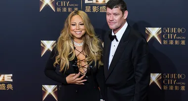 Two people smiling on a red carpet at an event, with Studio City Macau logos in the background.
