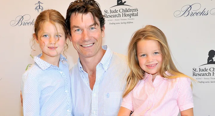 Actor with two smiling children at a charity event backdrop for St. Jude Children's Research Hospital.