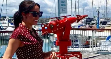 Meghan Markle arrives in Queensland in a burgundy polkadot dress