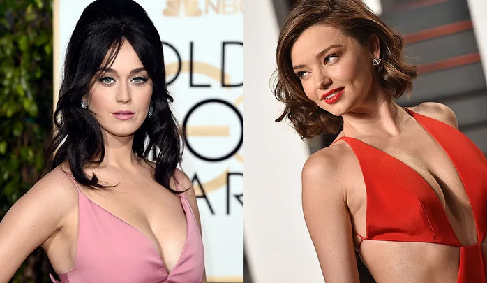 Two women at a glamorous event, one in a pink dress and the other in a red dress, posing for photos.