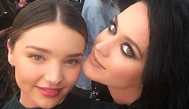 Two women taking a close-up selfie together, one with dark hair and the other with light brown hair.