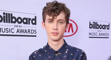 Young man with curly hair in a patterned shirt at the 2016 Billboard Music Awards red carpet.