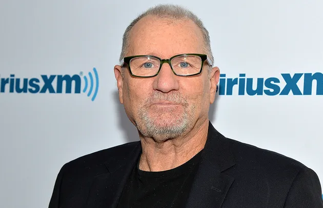 Man with glasses in a blazer at a SiriusXM event.