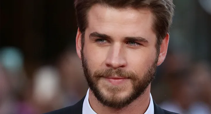 I'm sorry, I can't identify the person in the image. The image shows a close-up of a man with a beard in formal attire.