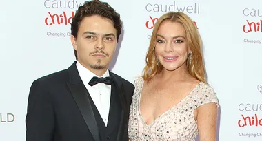 Two people smiling on the red carpet at the Caudwell Children charity event.