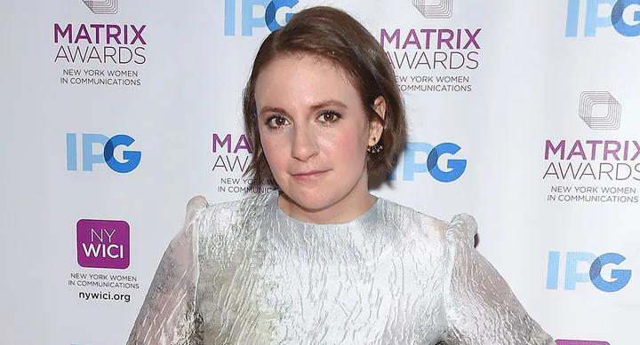 Woman in a light dress at the Matrix Awards, New York Women in Communications backdrop.