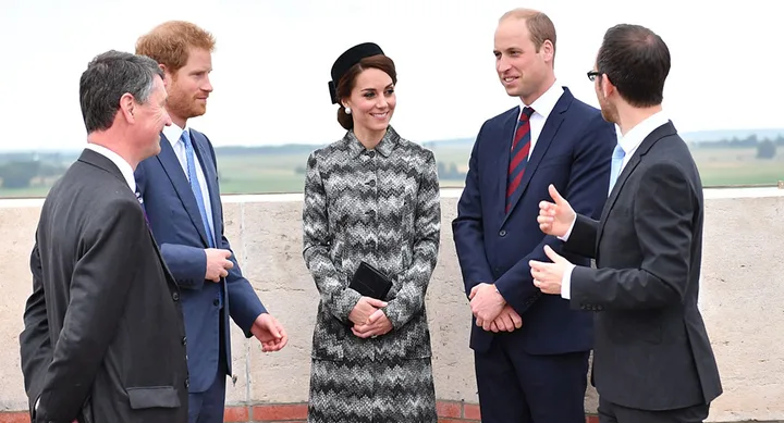 Five people in formal attire standing outdoors, engaged in conversation.