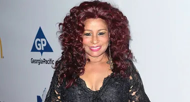 I don’t know who this is, but the person has red curly hair and is wearing a black outfit with lace details.