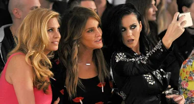 Group of people taking a selfie at an event, one holding a phone, others posing.
