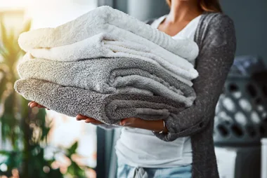 Lady carrying a pile of towels
