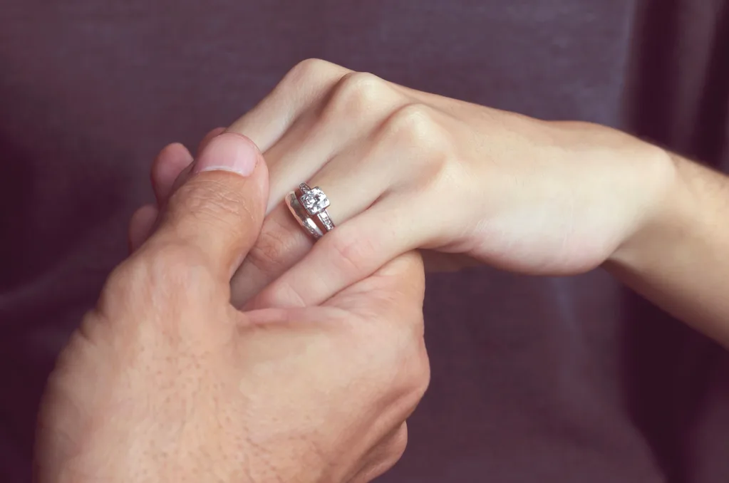 A silver engagement ring on a woman's hand
