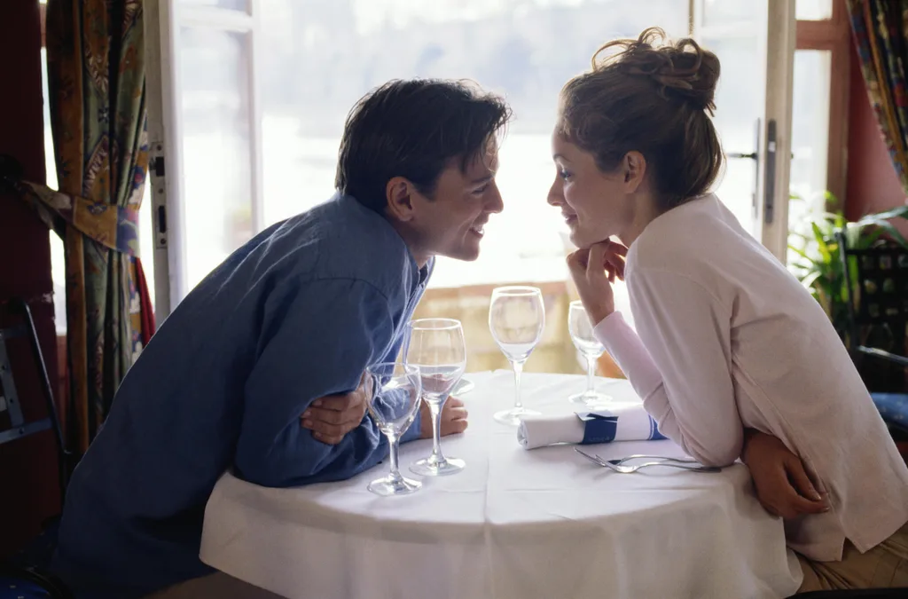 A couple sitting at a table together in a restaurant