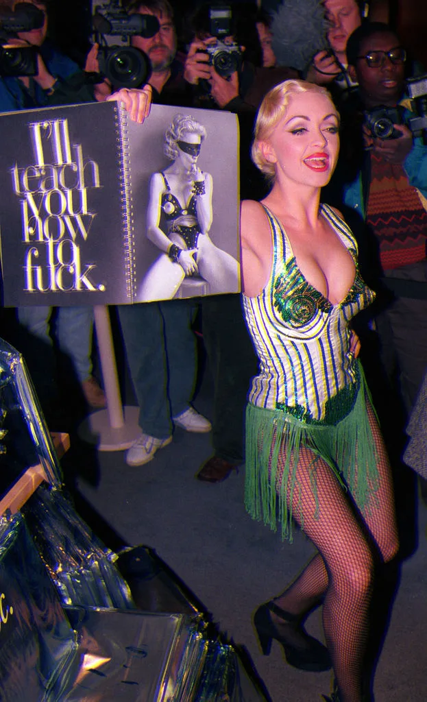 Madonna look-a-like holding a table book entitled SEX