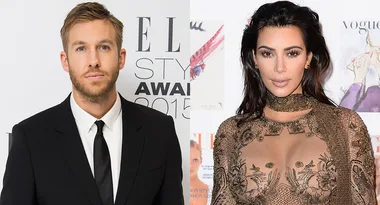 Two individuals at a fashion event; one in a suit and the other in a detailed dress.