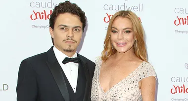 Two people posing on a red carpet in formal attire at a charity event.