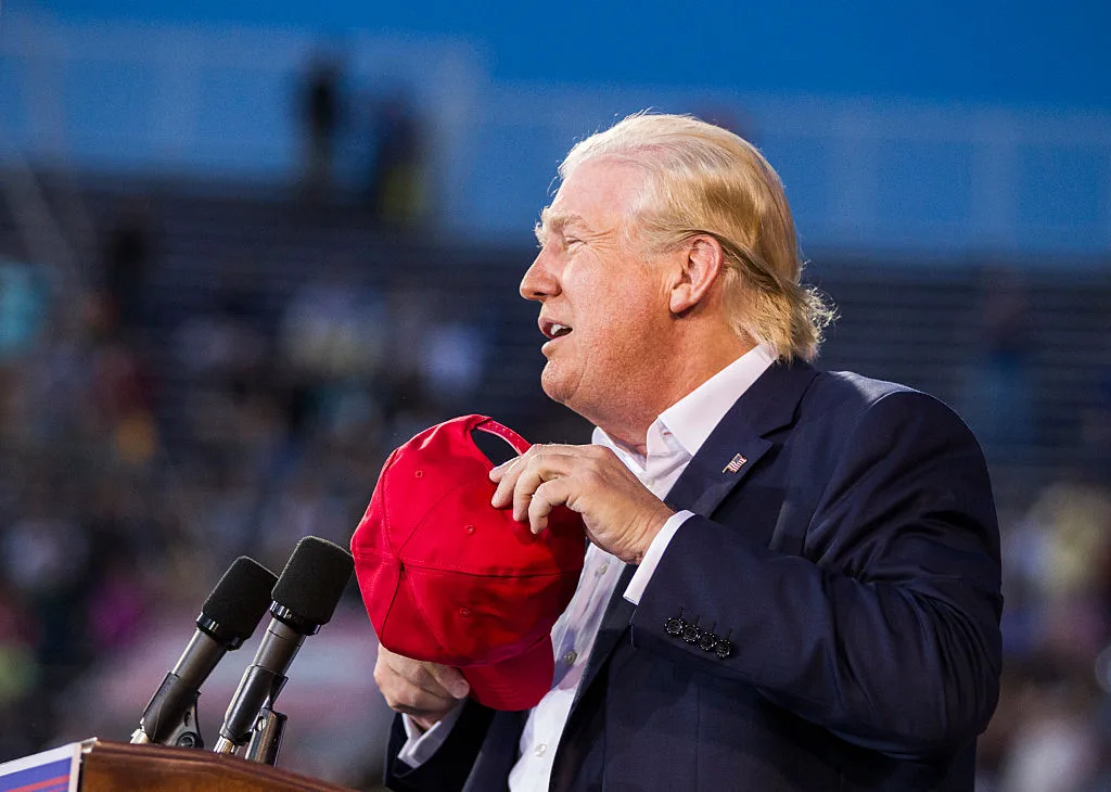 Donald Trump on stage holding hat