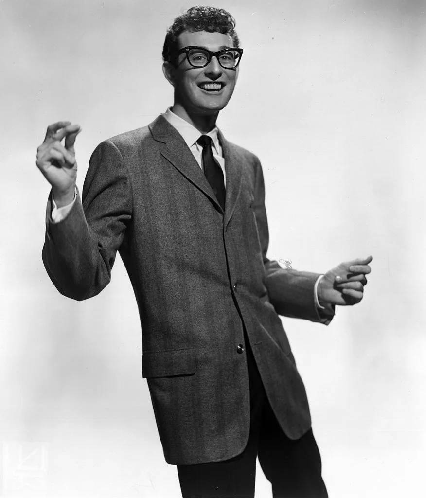 A black and white photo of Buddy Holly snapping his fingers