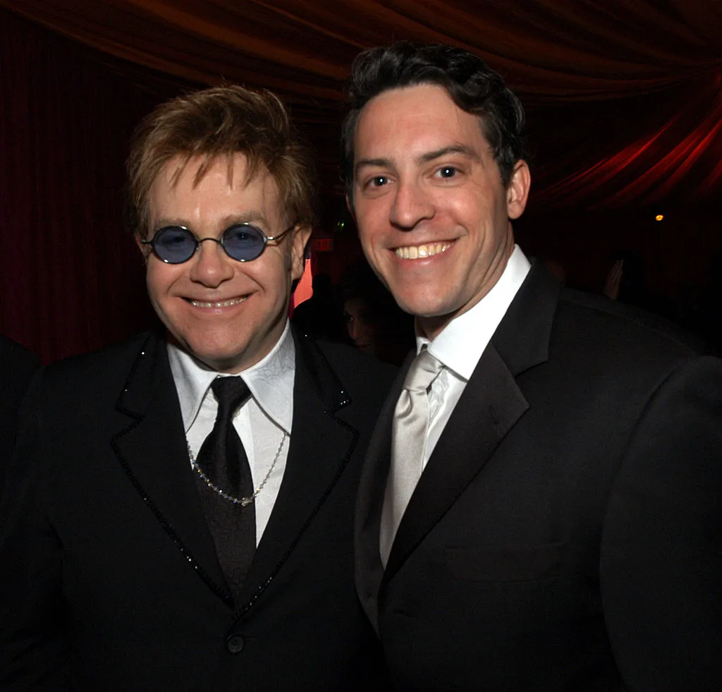 Elton John wearing small blue, circular glasses