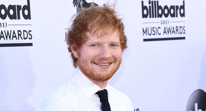 A person with red hair at the 2015 Billboard Music Awards, smiling in a white shirt and black tie.