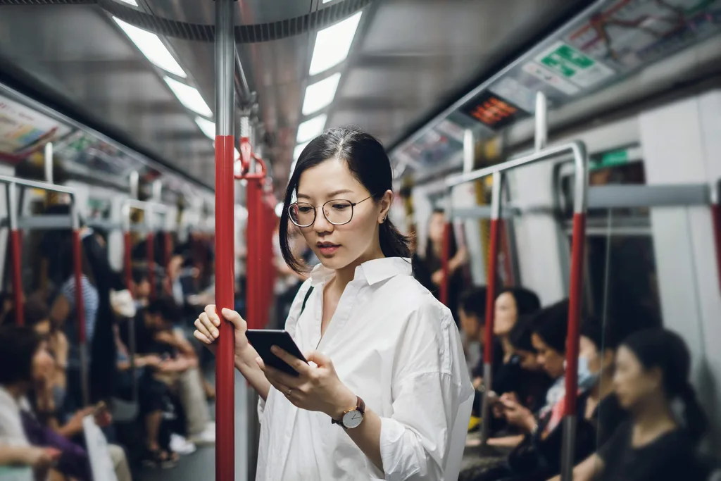 Young woman on a train looking at phone