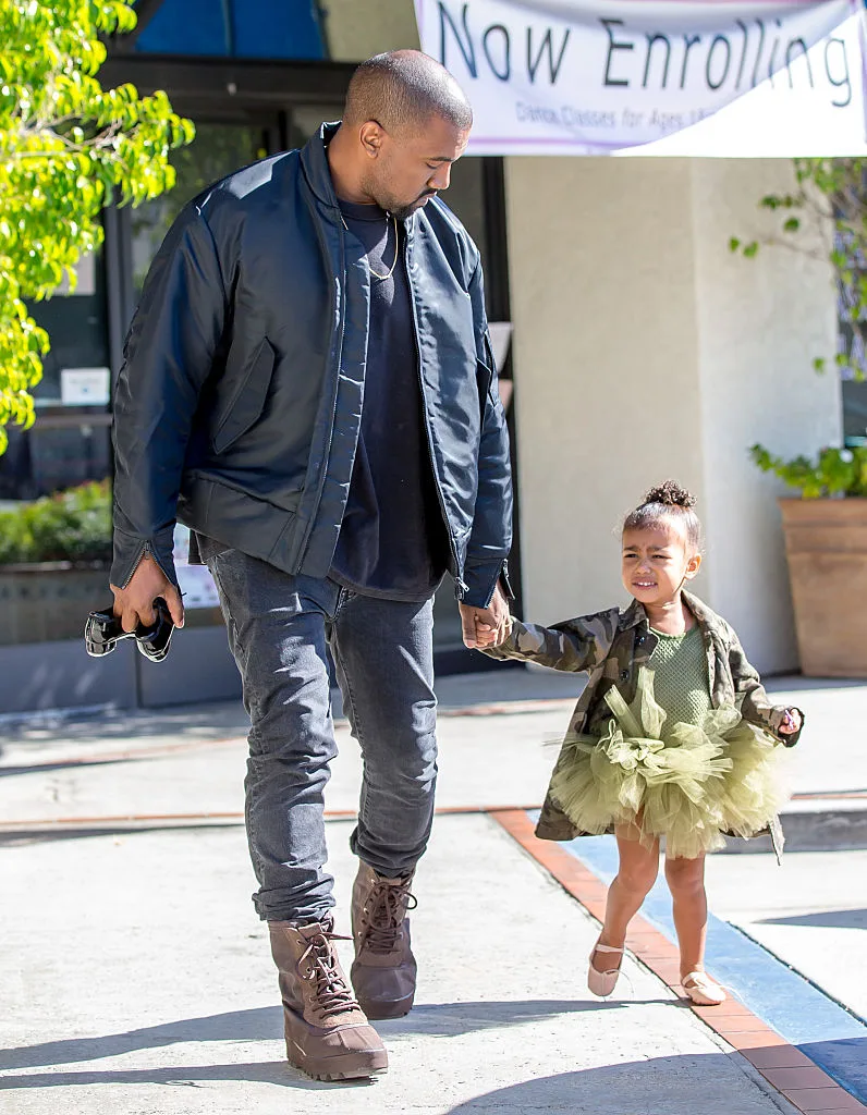 Kanye West wearing a bomber jacket and timberlands