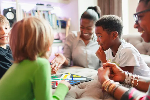 Family & Friends playing a game of Ludo board game