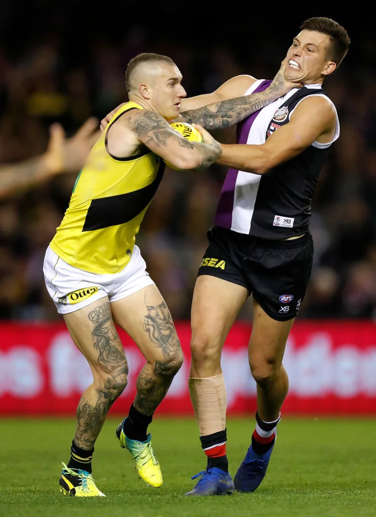 Dustin Martin fending off Rowan Marshall on the football field