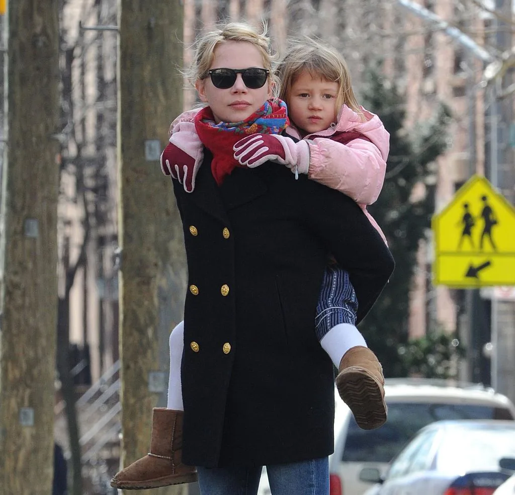 Michelle Williams in Brooklyn, NY with her daughter on her back
