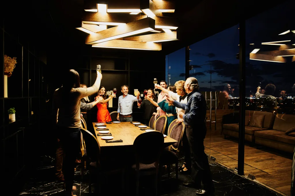 Group of friends around a dimly lit dinner table with drinks