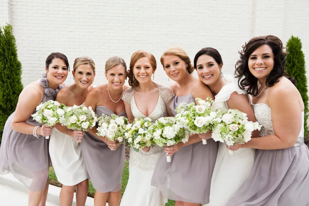 A group of bridesmaids wearing purple and white dresses