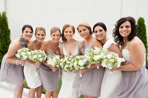 A group of bridesmaids wearing purple and white dresses